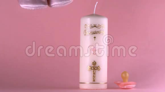 婴儿鞋落在洗礼蜡烛和奶嘴旁边视频的预览图