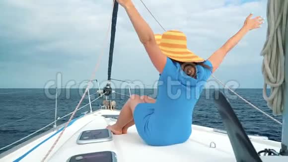 一位戴着黄色帽子的女士和一位穿着蓝色衣服的女孩在海洋的夏季靠近灯塔的游艇上休息视频的预览图