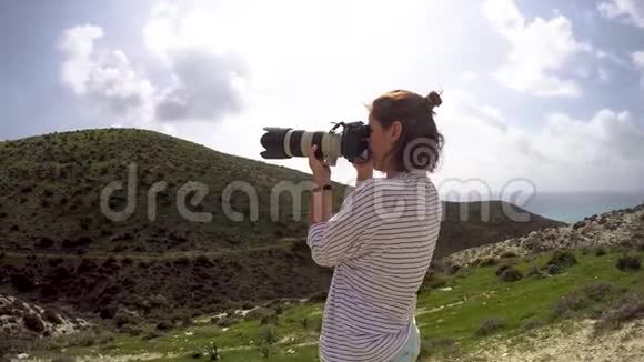 年轻女性专业摄影师拍摄风景视频的预览图