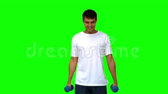 有魅力的男人在绿色屏幕上举起哑铃视频的预览图