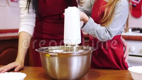 一个女儿用电动搅拌机混合配料视频的预览图