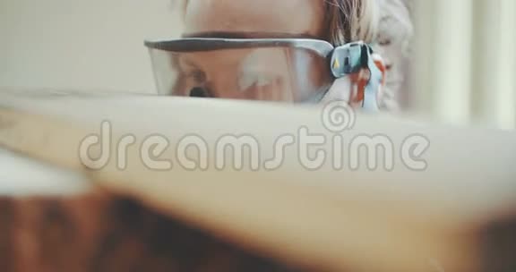 戴防护眼镜的专业木匠检验木材视频的预览图