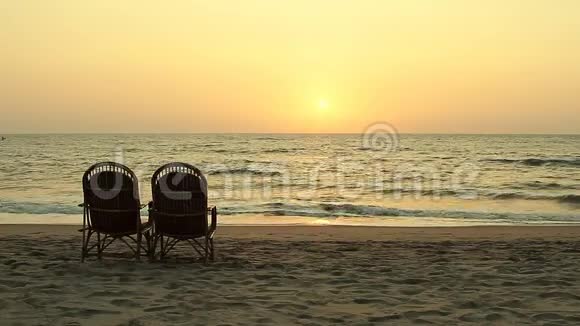 日落时靠近海岸线的椅子视频的预览图