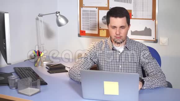 办公室工作人员坐在办公桌前用笔记本电脑的人视频的预览图