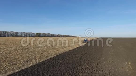 高空日落时拖拉机在秋天犁田视频的预览图