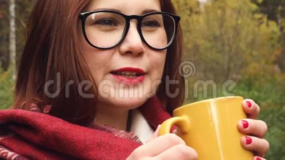 年轻女子从杯子里喝热茶以保暖视频的预览图