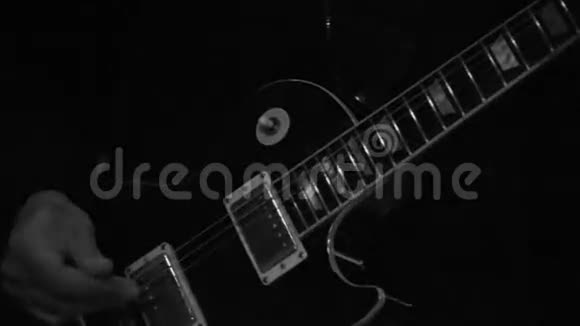 舞台上演奏吉他的黑白特写视频的预览图