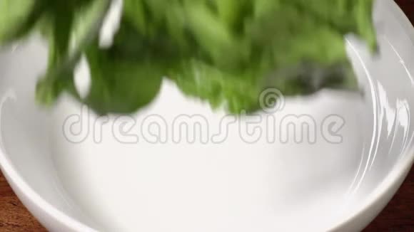 慢镜头的生菜落入碗上的木桌视频的预览图