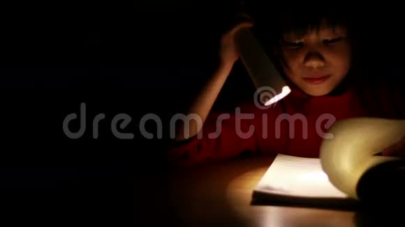 可爱的亚洲女孩在黑暗中看书视频的预览图