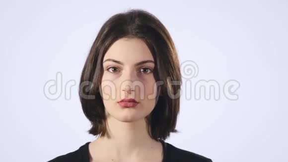 一个可爱的年轻白人女人在白色背景上做一张悲伤的脸视频的预览图