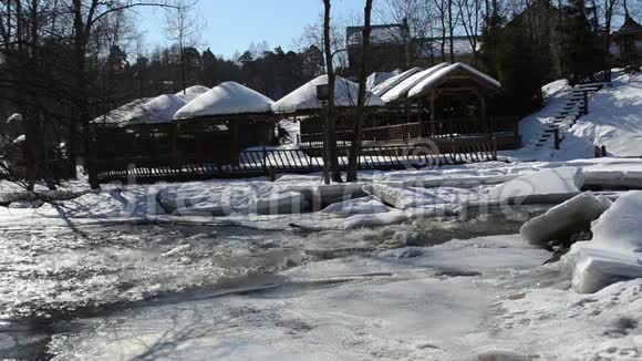 冰冻的河水木制的村庄屋顶覆盖白雪视频的预览图