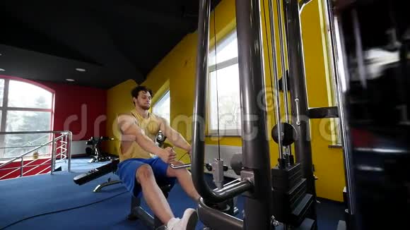 健身男子在健身房用机器锻炼视频的预览图