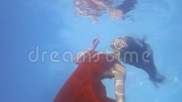 穿红色衣服的女人正在水下游泳水面上倒影4k视频的预览图