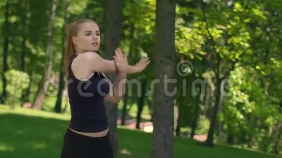 迷人的女跑步者在公园里伸展健身女孩做健身运动视频的预览图