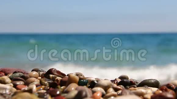 美丽的卵石海滩上海浪的背景视频的预览图