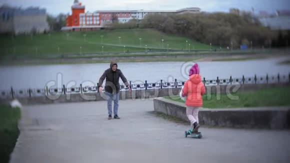 戴头盔骑踏板车的小女孩视频的预览图