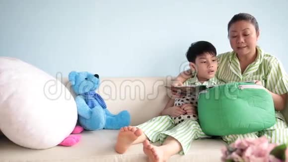 快乐的亚洲家庭一起在家沙发上看书视频的预览图