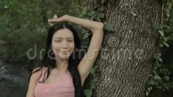 站在树旁的漂亮女孩视频的预览图