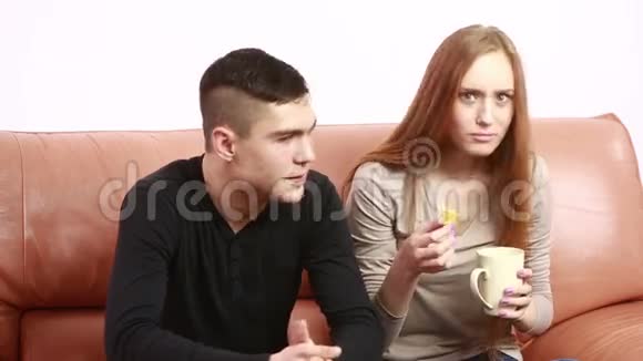 漂亮的年轻夫妇坐在沙发上争论不开心青年男女视频的预览图