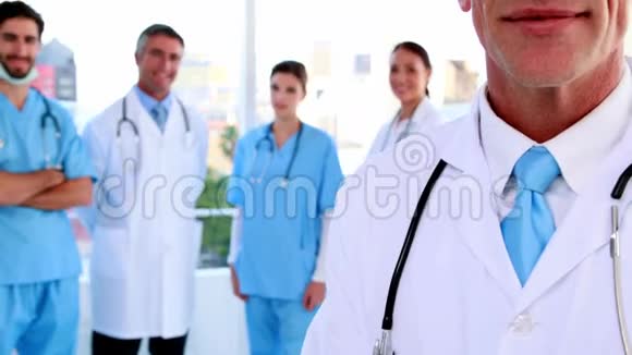 医生在镜头前微笑身后有团队视频的预览图