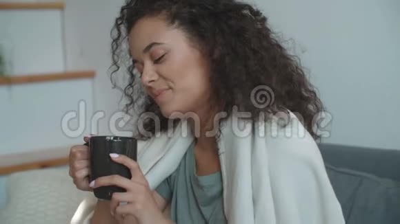 微笑的女人在家喝咖啡或茶的肖像视频的预览图