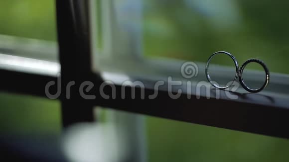 银色结婚戒指在窗户上阳光照射灯光照明宏观特写钻石首饰视频的预览图