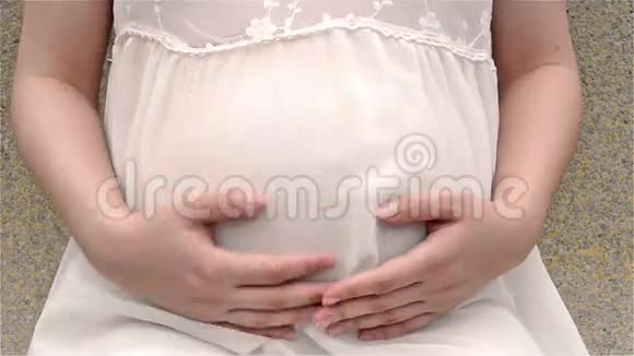 年轻孕妇抚摸着小宝宝的腹部视频的预览图