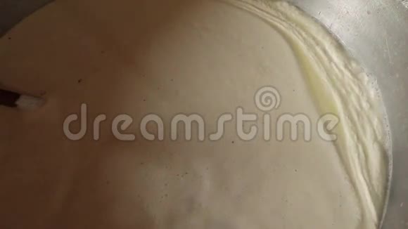 发酵牛奶在一个大锅中煮沸从上面的火焰特写视图视频的预览图