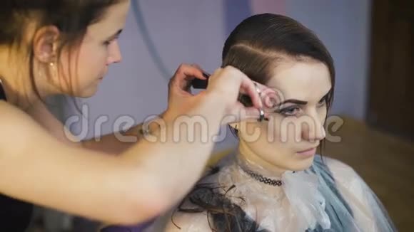 美容院里漂亮的女孩职业发型师给这位女士做了一个新的时尚发型视频的预览图