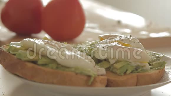 女人用牛油果做健康早餐烤面包鸡蛋和番茄视频的预览图