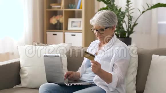 家里有笔记本电脑和信用卡的老年妇女视频的预览图
