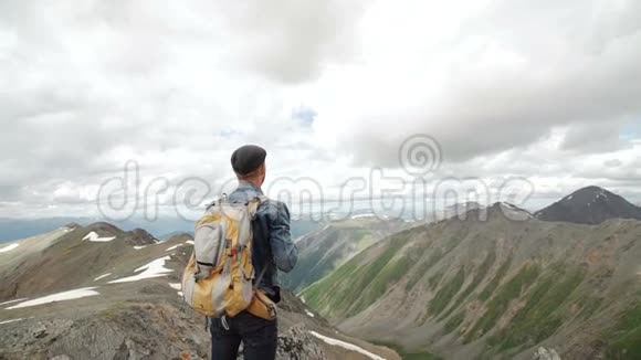 徒步旅行者背着背包站在山顶举起双手欣赏日出视频的预览图