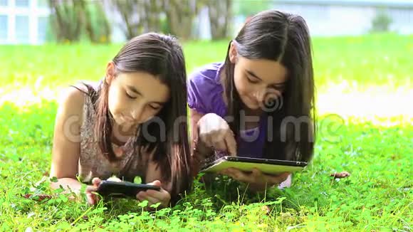 女孩玩数字平板电脑和智能手机视频的预览图