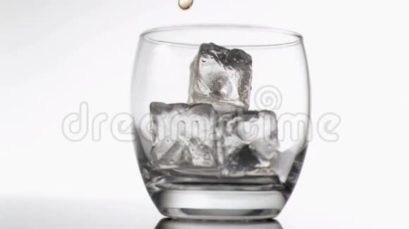 威士忌在装有冰块的玻璃杯中注入了非常缓慢的运动视频的预览图