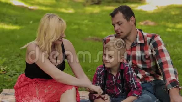 美丽幸福的家庭在阳光明媚的日子野餐视频的预览图