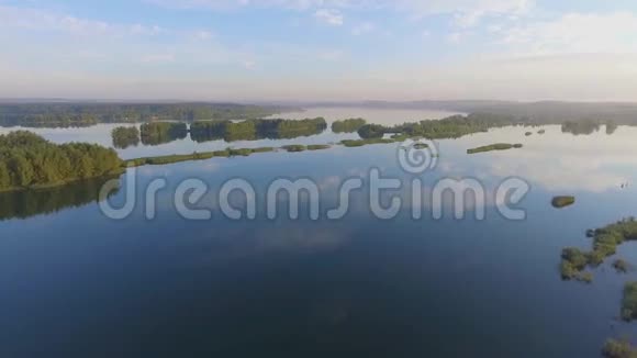 夏季日出湖泊和绿林沙滩和水中的倒影波兰兰斯克从上面看视频的预览图