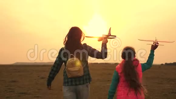 青少年想成为飞行员和宇航员快乐的女孩在田野日落时带着玩具飞机跑步幸福的概念视频的预览图