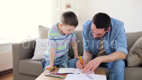 爸爸和小儿子在家里画蜡笔视频的预览图