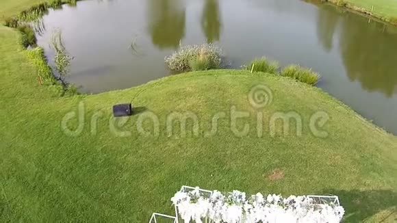 一架无人驾驶飞机飞过带有结婚拱门的绿色高尔夫球场视频的预览图