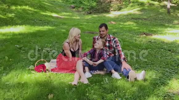 美丽幸福的家庭在阳光明媚的日子野餐视频的预览图