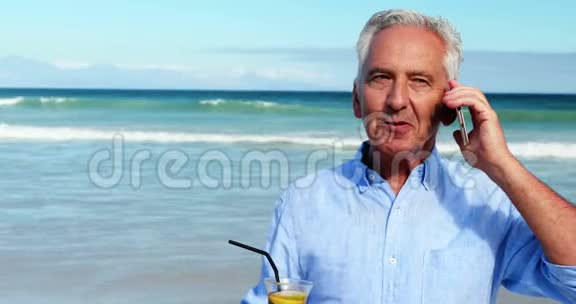 老人在海滩上用手机聊天视频的预览图