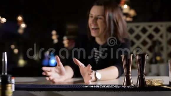 酒保给那位漂亮的黑发女人放了一杯独家鸡尾酒酒吧里的幽默和笑声视频的预览图