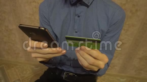 年轻的高加索人用信用卡在智能手机上从互联网上购买商品视频的预览图