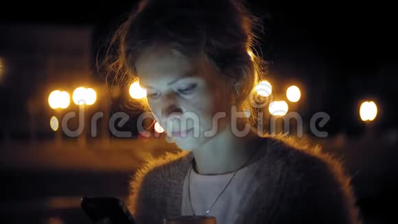 晚上在市中心时年轻女子在手机上发短信快乐的女性在城里用智能手机发短信视频的预览图