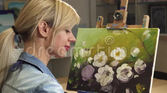 艺术工作室一位从事绘画工作的女艺术家的后景特写视频的预览图