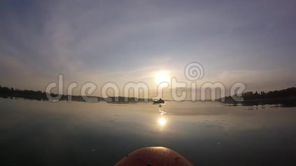 在冲浪板上划船太阳背景上的SUP板日出视频的预览图
