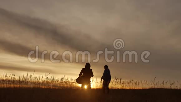 人们集体旅行的游客野外自然的一个夕阳剪影两个人旅行的生活方式游客视频的预览图