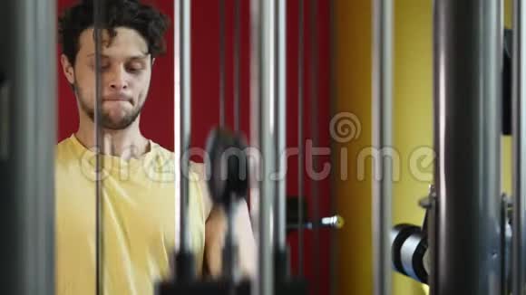 健身男子在健身房用机器锻炼视频的预览图