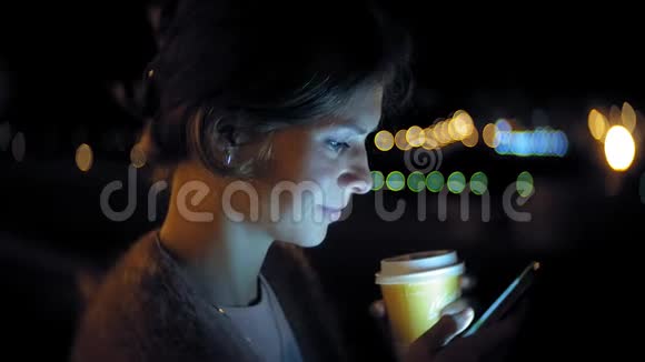 晚上在市中心时年轻女子在手机上发短信快乐的女性在城里用智能手机发短信视频的预览图