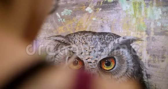 女艺术家画了一幅萨满画艺术家在她的车间里用丙烯酸颜料描绘画布上的画面视频的预览图